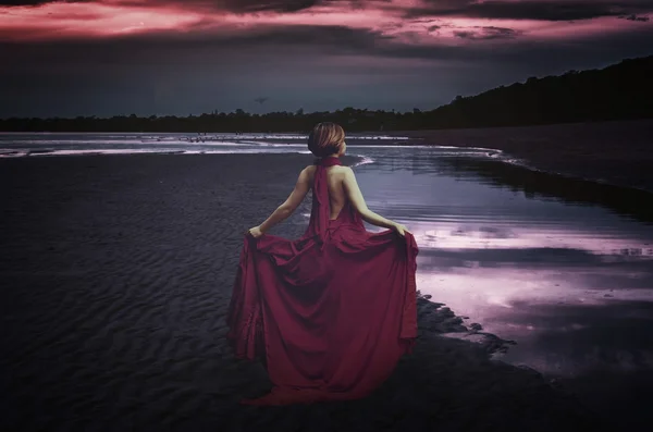 Mulher com vestido no oceano à noite — Fotografia de Stock