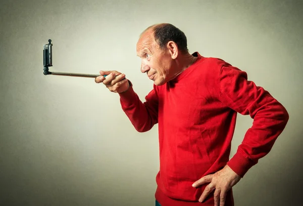 Портрет смішного старшого чоловіка, що бере селфі — стокове фото