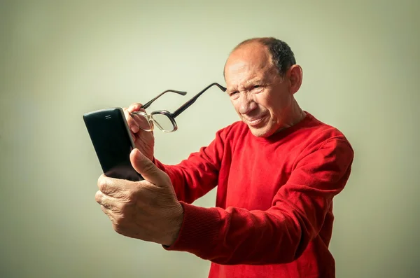 Portret zabawny człowiek starszy patrząc na telefon — Zdjęcie stockowe