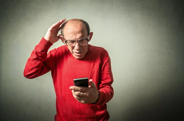 Portret zabawny człowiek starszy patrząc na telefon — Zdjęcie stockowe