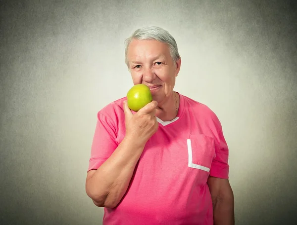 Senior woman with eating apple — Stock Photo, Image