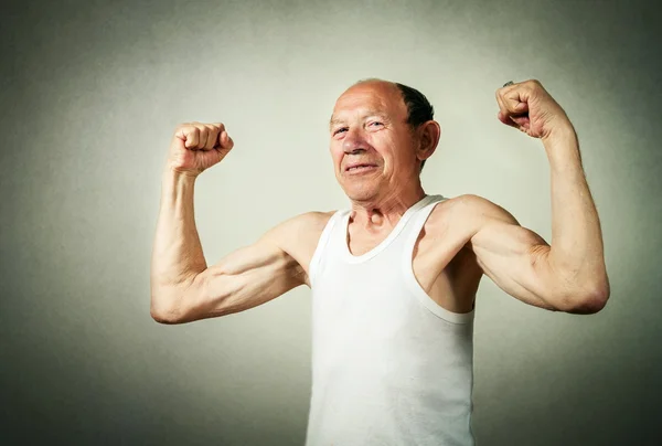 Смешной пожилой человек показывает мышцы — стоковое фото