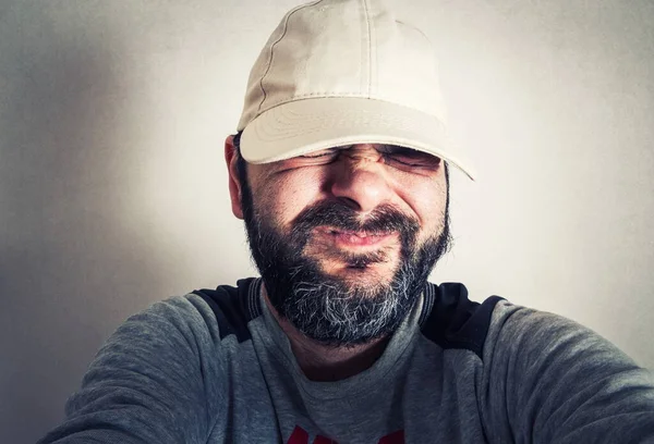 Sakallı komik adam surat ifadeleri yapıyor.