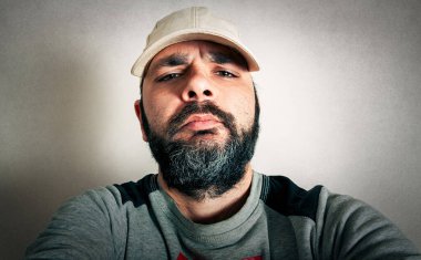 Sakallı komik adam surat ifadeleri yapıyor.