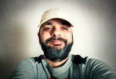 Sakallı komik adam surat ifadeleri yapıyor.