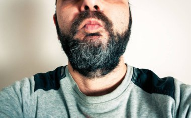 Sakallı komik adam surat ifadeleri yapıyor.