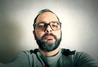 Sakallı komik adam surat ifadeleri yapıyor.