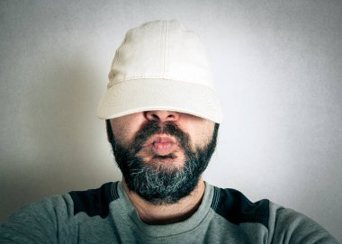 Sakallı komik adam surat ifadeleri yapıyor.