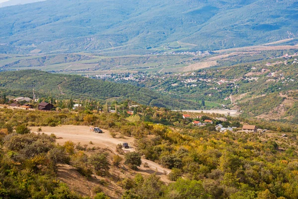 Güneşli bir günde dağlık arka planda yeşil bir vadi manzarası
