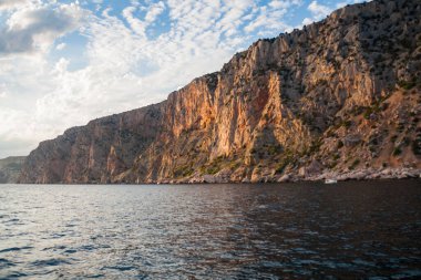 Güneş, denizin üzerindeki bulutların arasından aydınlanıyor.