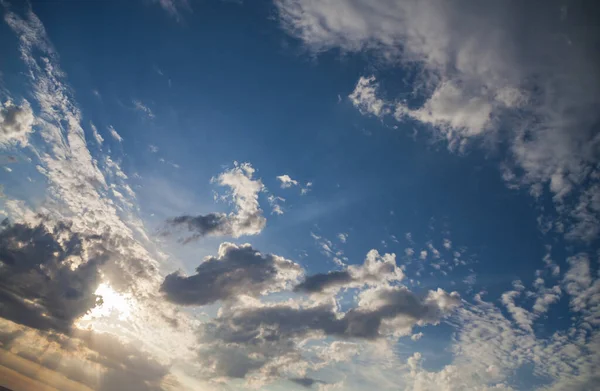 Güneş bulutların arasından aydınlanıyor mavi gökyüzü