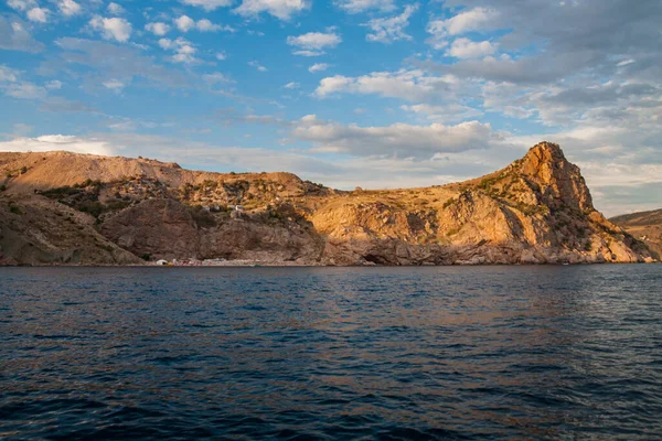 Güneş, denizin üzerindeki bulutların arasından aydınlanıyor.