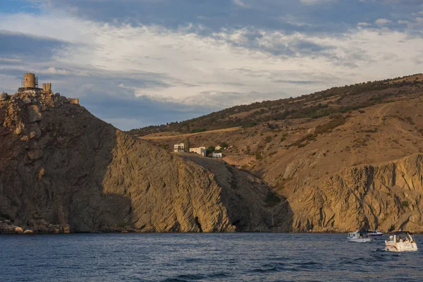 Güneş, denizin üzerindeki bulutların arasından aydınlanıyor.