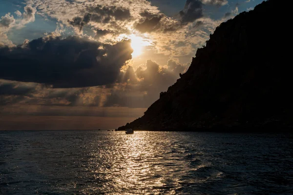 Солнце светит сквозь облака над морем — стоковое фото