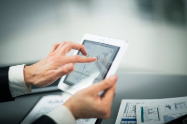 Dijital tabletin ekranına dokunan bir iş adamı
