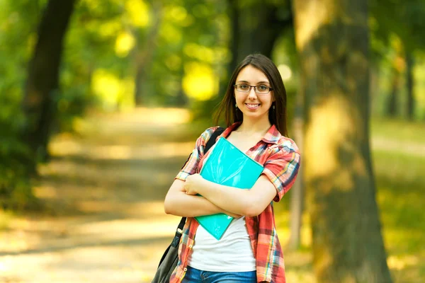 Erfolgreiche Studentin mit Büchern im Park an einem sonnigen Tag — Stockfoto