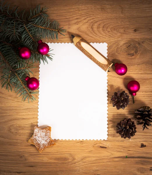 Blankt papper på trägolvet med en penna och julpynt — Stockfoto