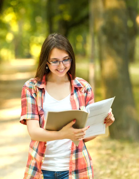Framgångsrik student med böcker i parken på en solig dag — Stockfoto