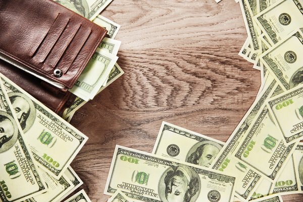 photo wallet and banknotes of dollars on wooden background