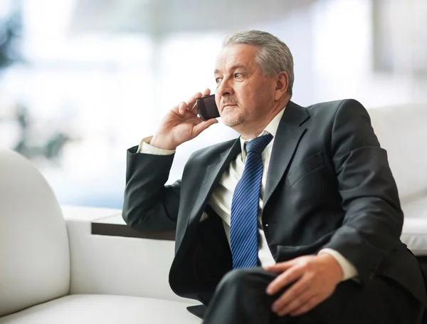 Successful businessman talking on smartphone in office — Stock Photo, Image