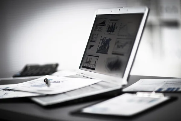 Empresario analizando gráficos de inversión con laptop. — Foto de Stock