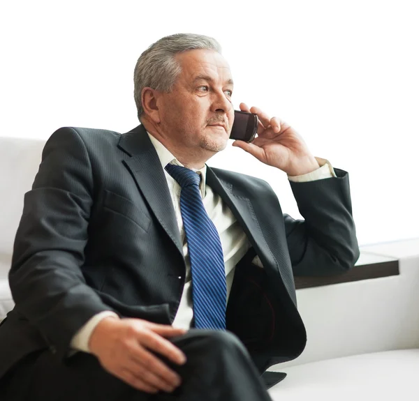 Erfolgreicher Geschäftsmann spricht im Büro auf dem Smartphone — Stockfoto