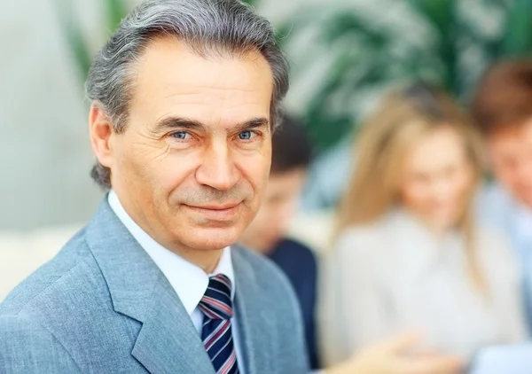 Portrait de heureux homme d'affaires réussi sur fond de bureau — Photo