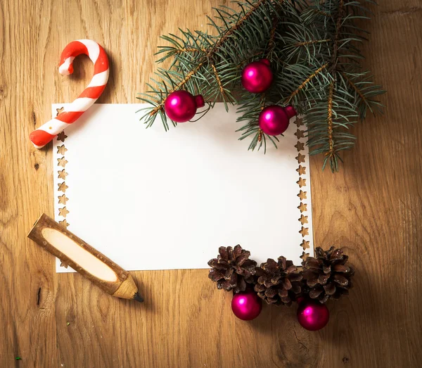 Hoja de papel en blanco para la felicitación y el lápiz en el fondo de Navidad —  Fotos de Stock