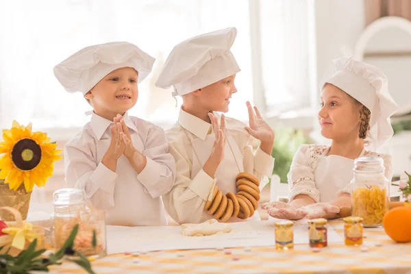 Crianças pequenas felizes na forma de um chef na cozinha — Fotografia de Stock