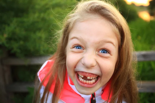 Cute little girl smiling in a park close-up — Stock Photo, Image