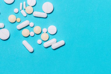 Mavi arka planda tabletler, vitaminler ve diyet takviyeleri .