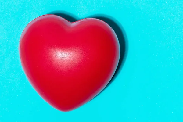 red heart, pills and dietary supplements on a blue background .