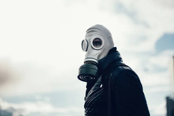 Casual jongeman in een gasmasker staan op straat in een lege stad — Stockfoto