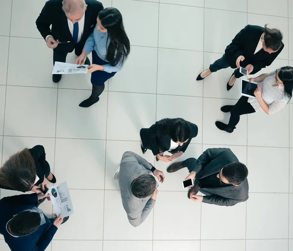 Vista dall'alto. dipendenti che discutono i dati finanziari prima della riunione. — Foto Stock