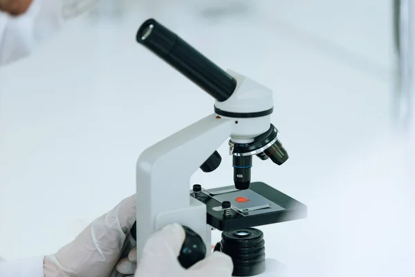 De cerca. científico utiliza un microscopio en un laboratorio moderno. — Foto de Stock
