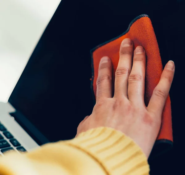 Frau sprüht Antiseptikum auf die Oberfläche eines Laptops. — Stockfoto