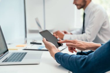 Kapat. Ofiste akıllı telefonunu kullanan bir işadamı. .