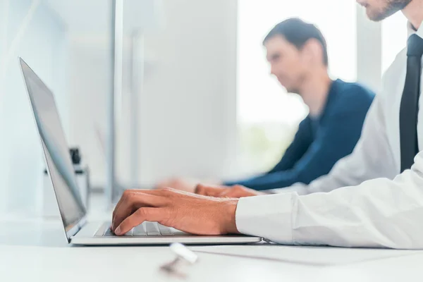 De près. employé travaille sur un ordinateur portable dans le bureau. — Photo