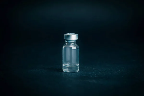 De cerca. ampolla médica sobre un fondo oscuro. —  Fotos de Stock