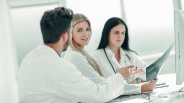 Radyoloji doktoru meslektaşlarına röntgen gösteriyor..