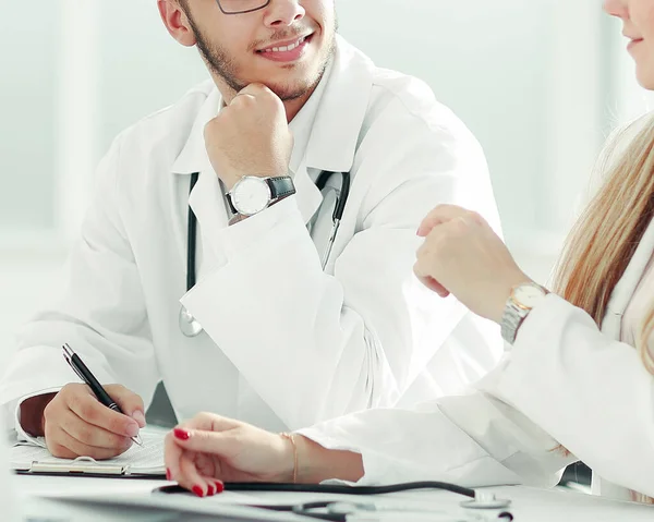 Artsen collega 's praten zitten aan een tafel in het kantoor — Stockfoto