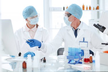 Bilim adamları modern bir laboratuvarda araştırmanın sonuçlarını tartışıyor..