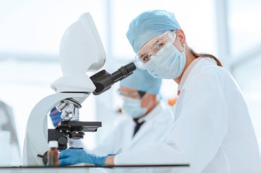 Bilim adamları sıvıyı test ediyor ve sonuçları laboratuvar dergisine yazıyorlar..