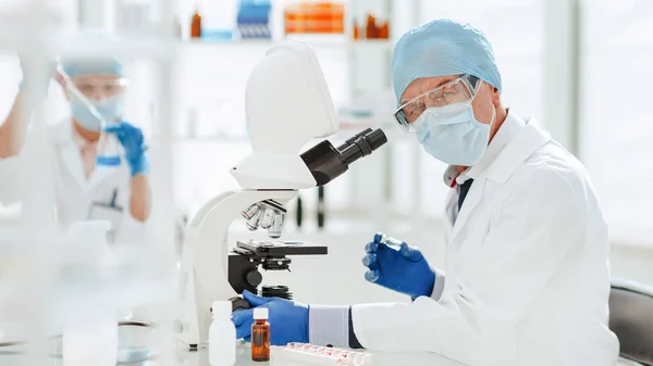 Cientista usando um microscópio em um laboratório bioquímico. — Fotografia de Stock