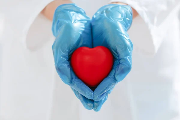 Doe dicht. symbool van het hart in de handen van een arts. — Stockfoto
