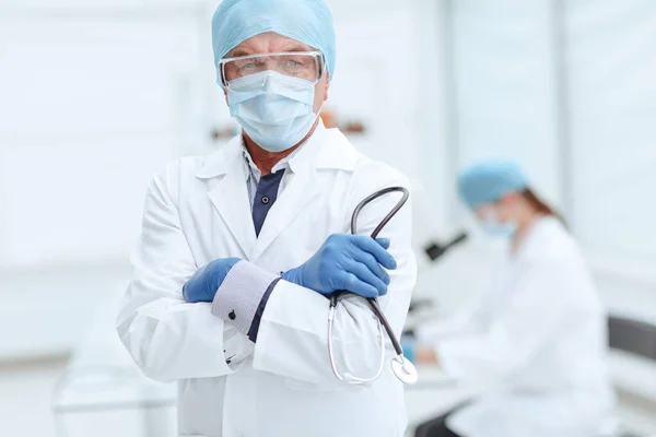 Médico practicante con un estetoscopio en las manos sobre el fondo del laboratorio. —  Fotos de Stock