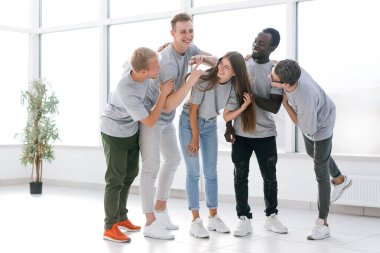 Neşeli genç iş ekibi yeni ofisinde duruyor..