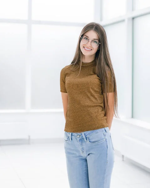 Smiling young woman standing in bright office . — Stock Photo, Image