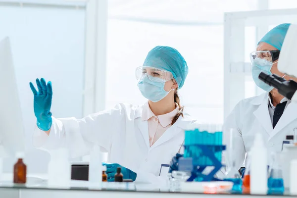 Grupo de cientistas que discutem dados em linha no laboratório. — Fotografia de Stock