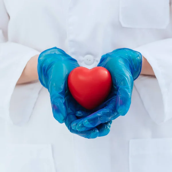 Doe dicht. arts in beschermende handschoenen houdt het hart vast . — Stockfoto